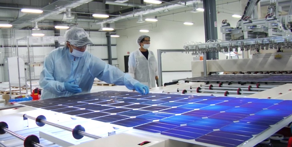 Mission Solar employee closely inspects each module for possible flaws.