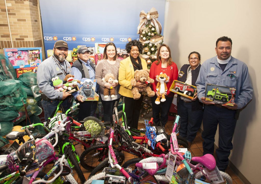 (Image) President &amp; CEO Paula Gold-Williams (Center) joins Maria Garcia, Vice President of Community Engagement, (Center Right) and other employees to show off mounds of toys employees collected for Angel Tree.