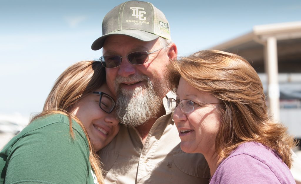 (Image) Will Schneider reunites with his family after helping restore electricity after Hurricane Harvey.