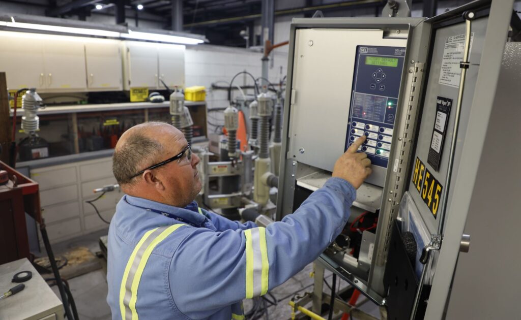 A photo of CPS Energy crew working on a transformer shop control panel